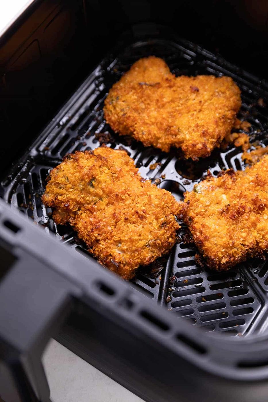 fried chicken cooking in an air fryer basket