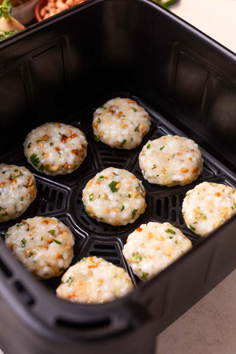 An image of uncooked air fryer sabudana vadas placed in the air fryer ready to bake