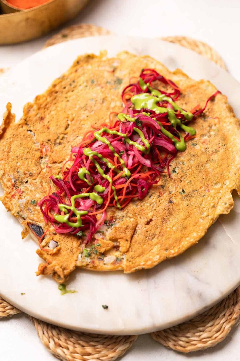 a flatlay image of anda paratha with filling in the middle