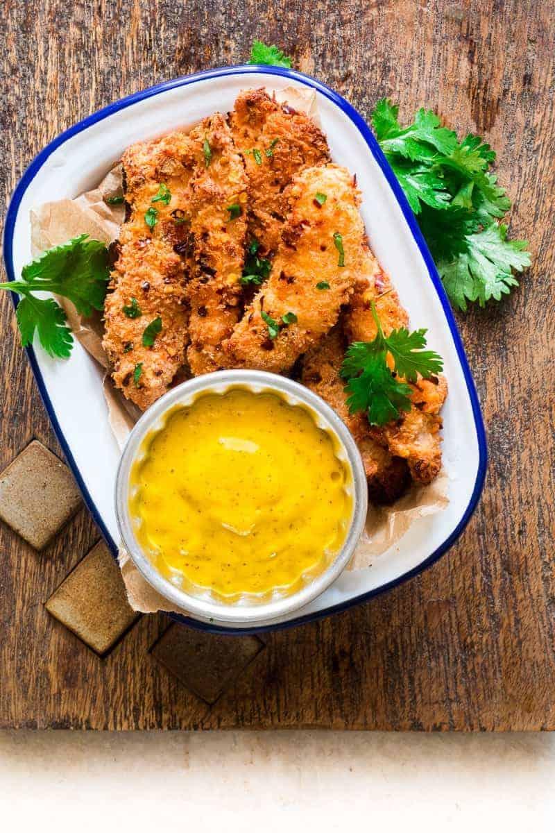 Easy recipe for super crunchy baked coconut crusted chicken tenders which are going to be a favourite at every party with kids and adults alike! Gluten free too.