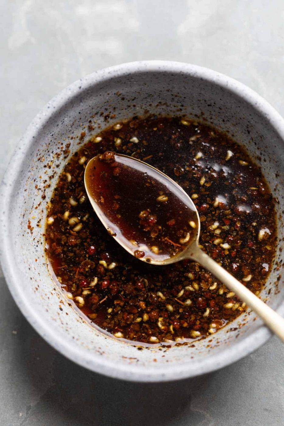sauce for black pepper chicken in a bowl with spoon