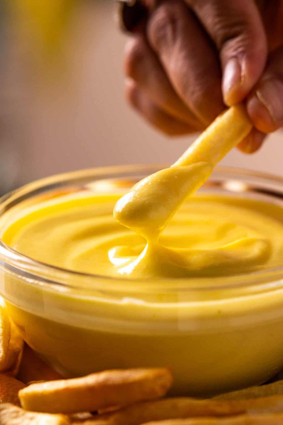 person dipping french fry in boiled egg mayo