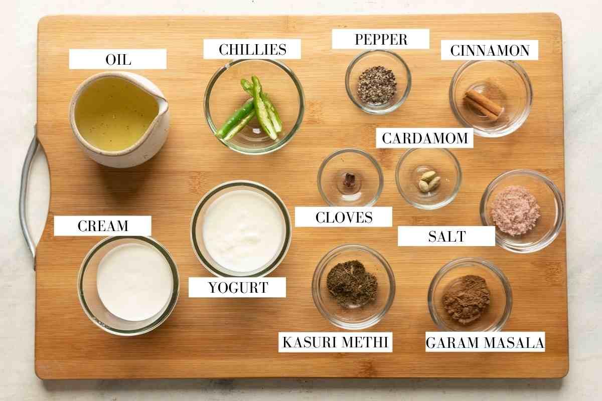 Ingredients for making the gravy for chicken kali mirch on a brown board with text to identify them