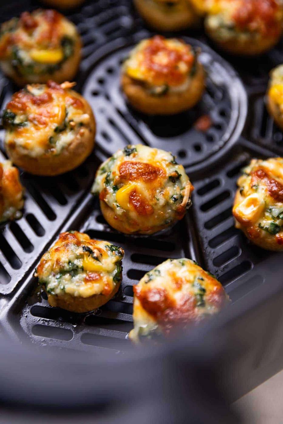 freshly baked air fryer stuffed mushroom lined up in the air fryer