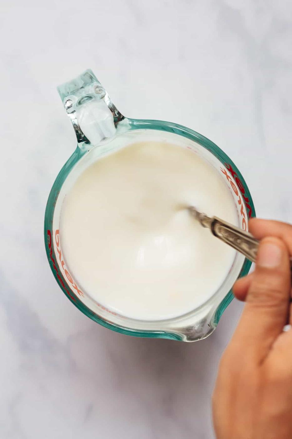 Stirring the ingredients to make buttermilk at home.
