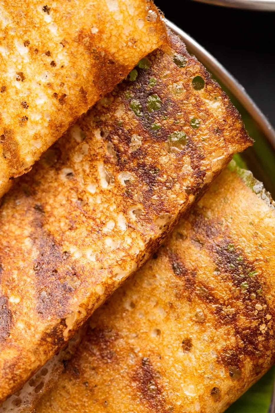 Closeup of dosas to show the crispy lacy texture thats a beautiful golden brown in colour