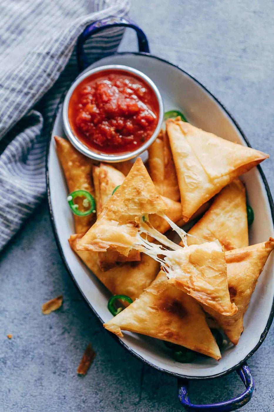 Super cheesy jalapeno three cheese samosa are sure to become a favourite because who can resist gooey stringy cheese stuffed in crispy samosa wrappers! These vegetarian samosas have a filling of mozzarella, cream cheese, smoked cheddar and jalapenos and folding them is really easy too.