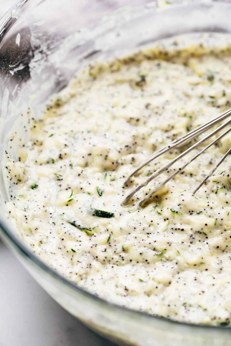 Lemon Zucchini Bread cake batter in a bowl with a whisk