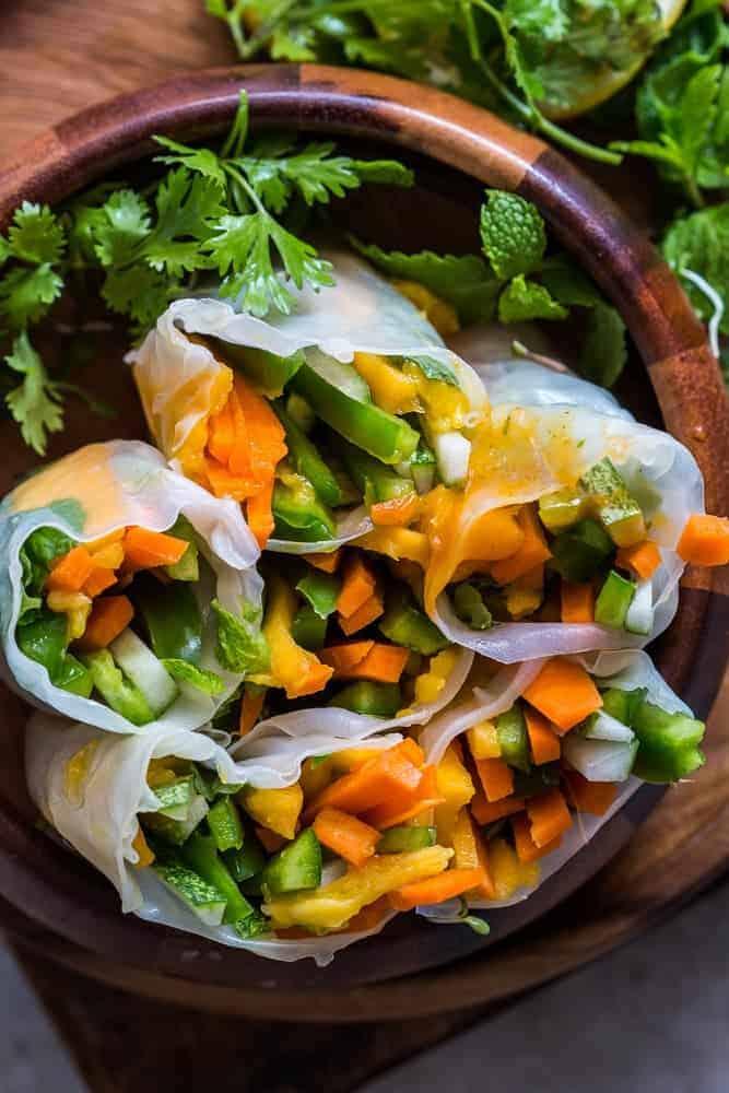 These mango bell pepper rice paper rolls are the perfect summer food! They are stuffed with lots of amazing veggies and come with an insanely delicious mango cilantro dipping sauce! These are naturally gluten free, vegan and low carb!