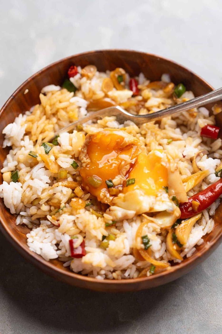 an image of Mayak Eggs poured over steamed rice and served in a wooden bowl with a spoon