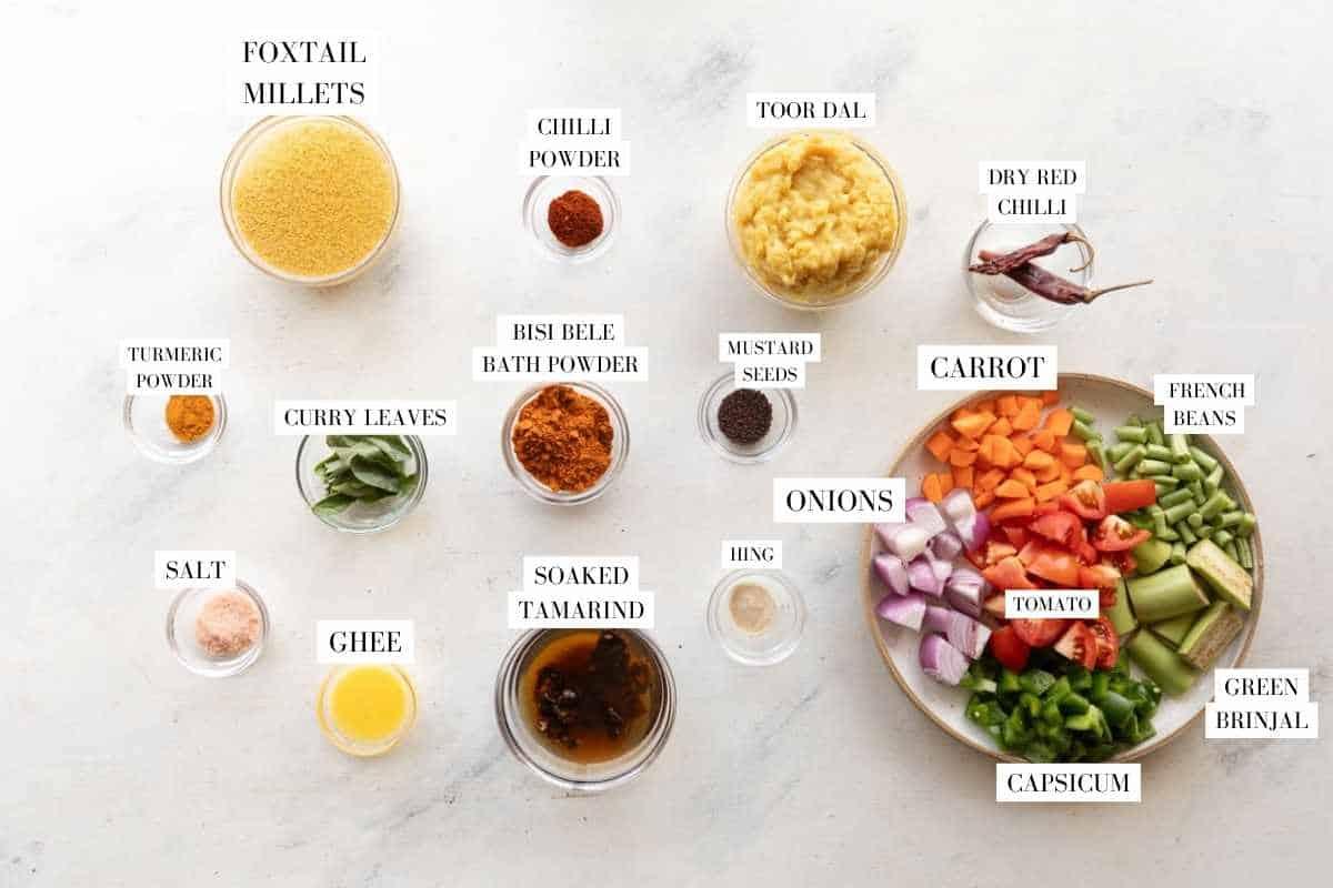 Picture of all the ingredients for Millet Bisi Bele Bath with text to identify them