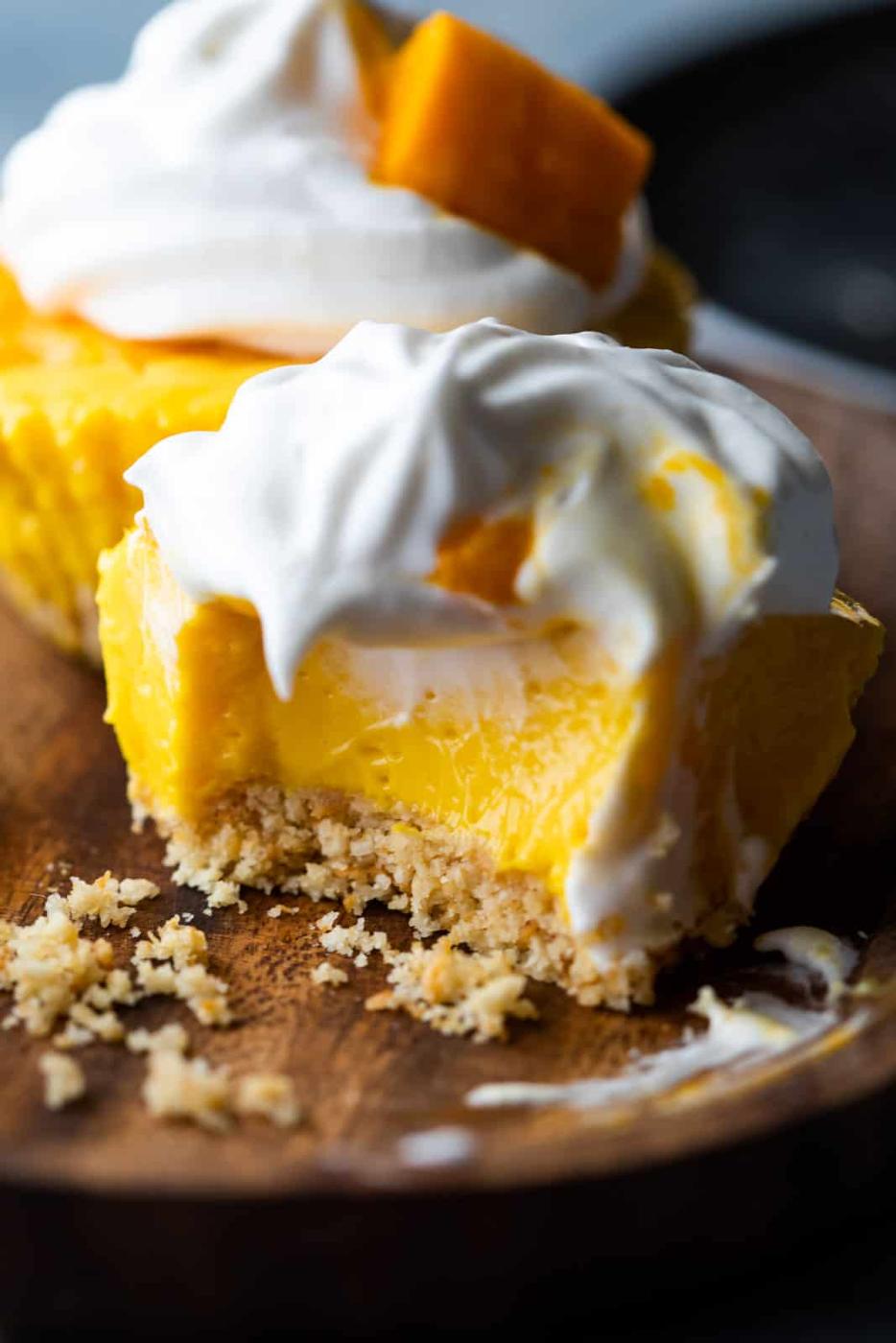 Closeup of a bite takes out of mini mango cheesecakes to show texture