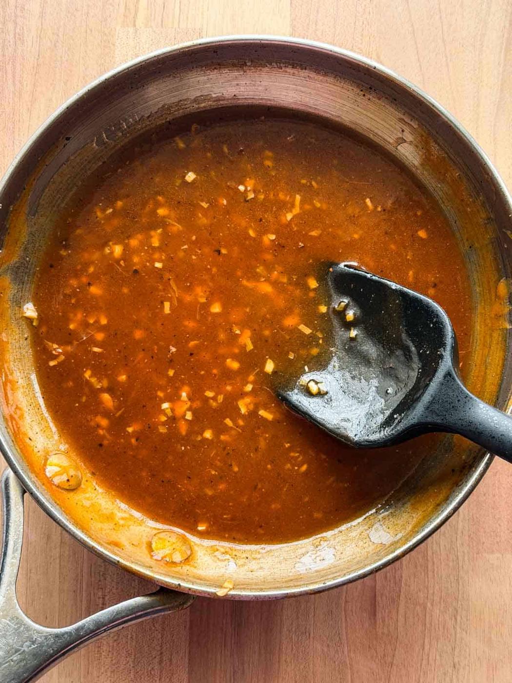shashlik sauce in its cooking pan with ladle