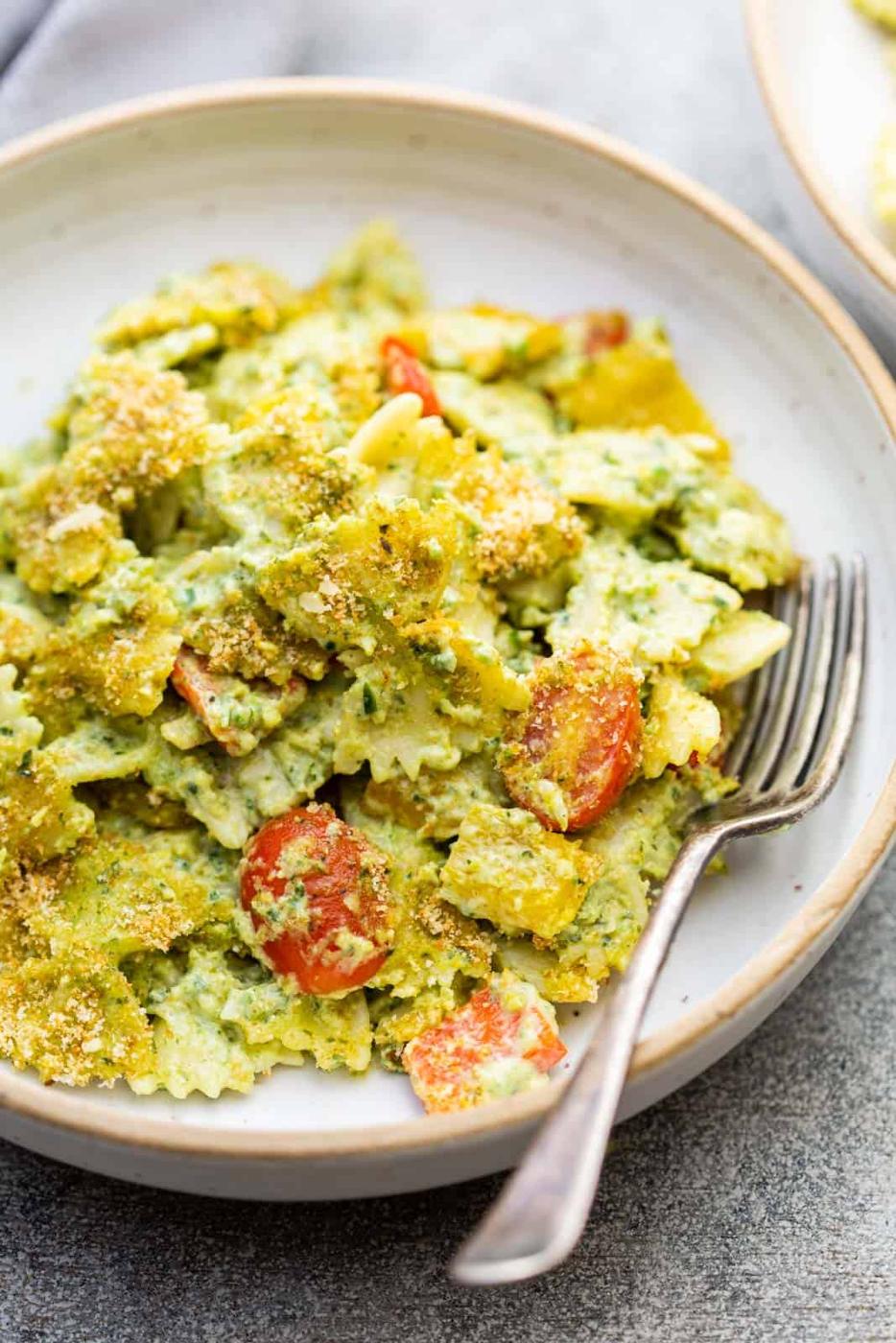 Closeup of pasta in jalapeno pesto served in a pasta bowl with a fork