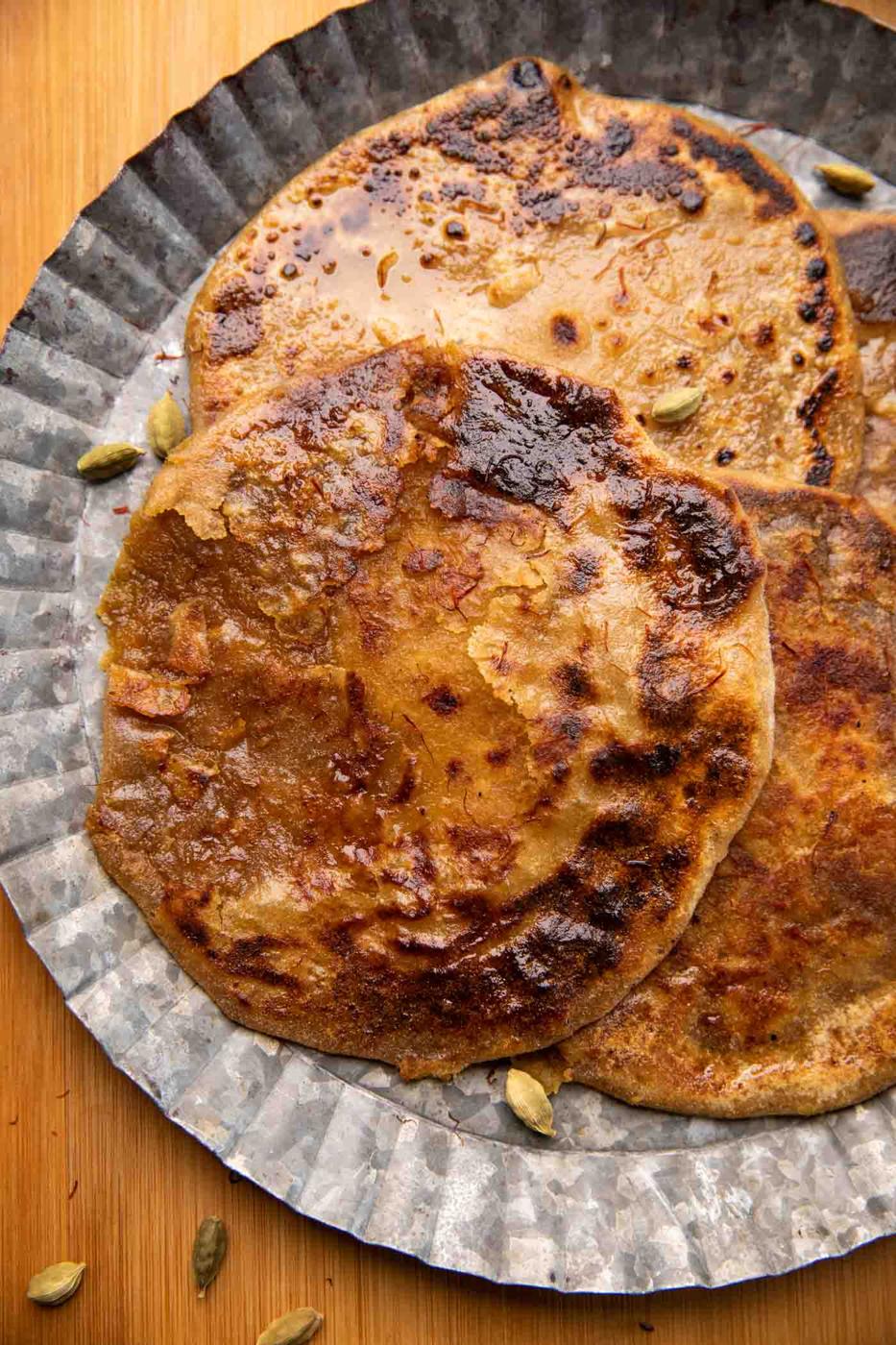 Puran polis served on a silver platter drizzled with saffron and ghee