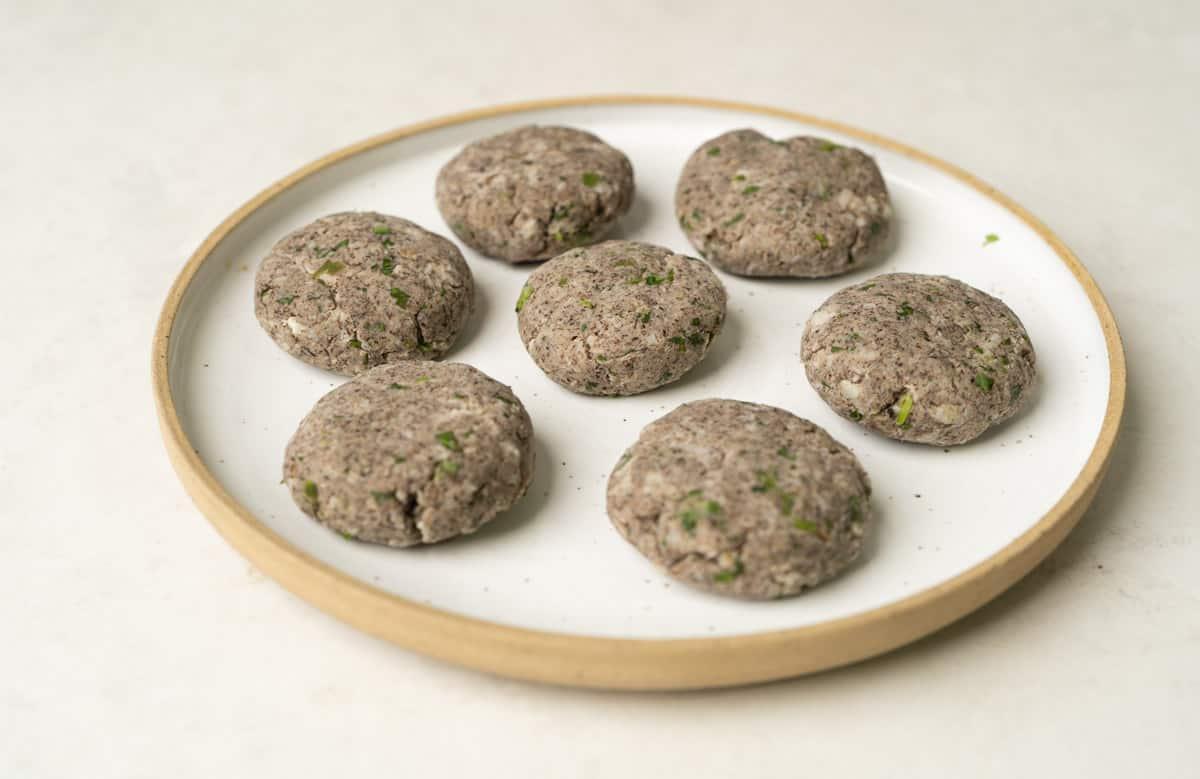 raw banana tikki or kachhe kele ke kebab shaped and placed on a white plate