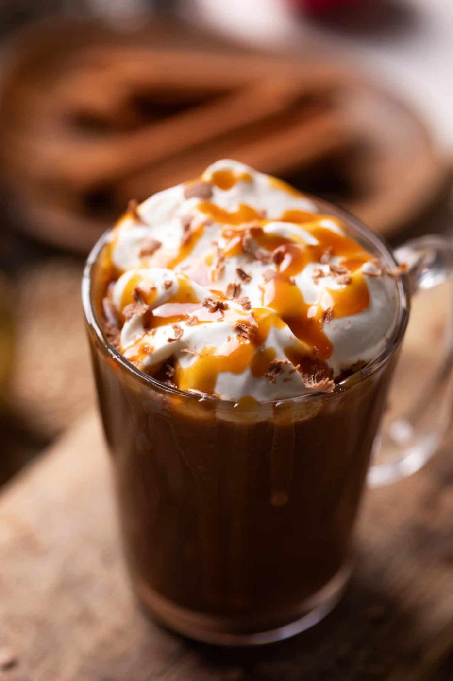 salted caramel hot chocolate topped with whipped cream and caramel served in a mug