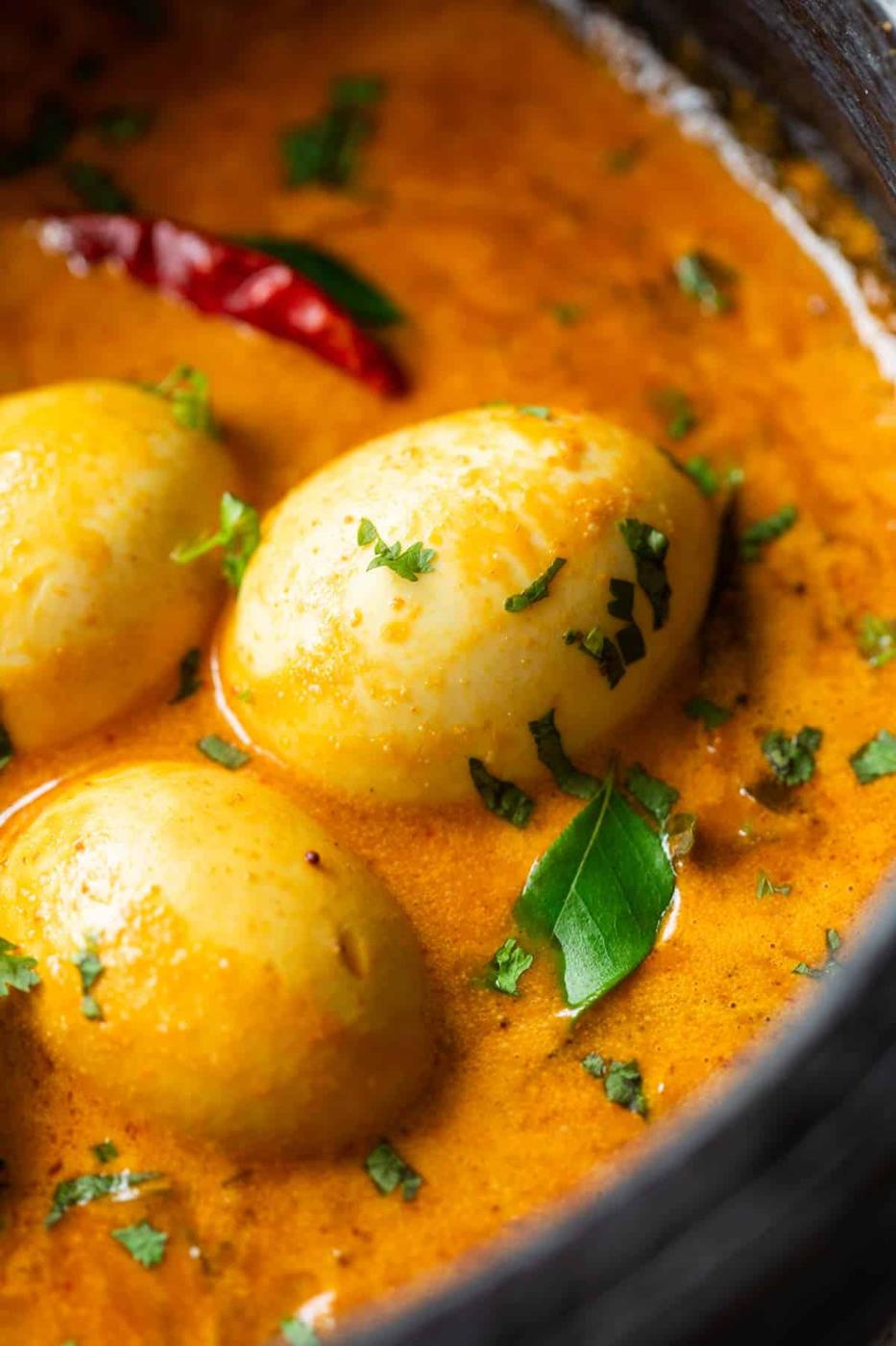 close up image of south indian style egg curry to show the creamy texture and perfectly boiled eggs