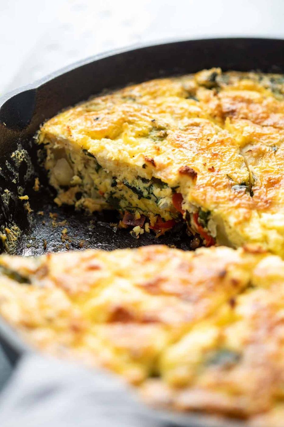 Closeup of sliced spinach potato veggie frittata in a cast iron skillet