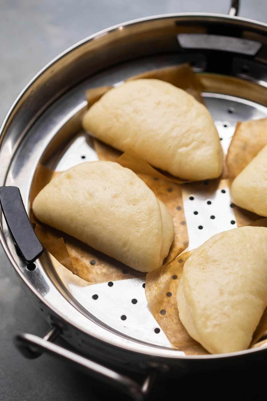 freshly steamed bao buns still in the steamer