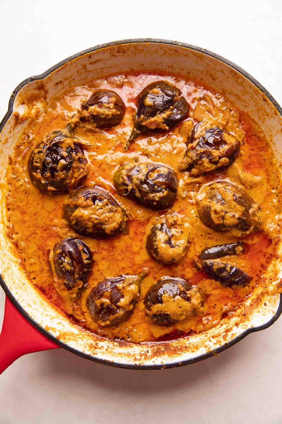 Picture of stuffed brinjal curry in a red enamel pan