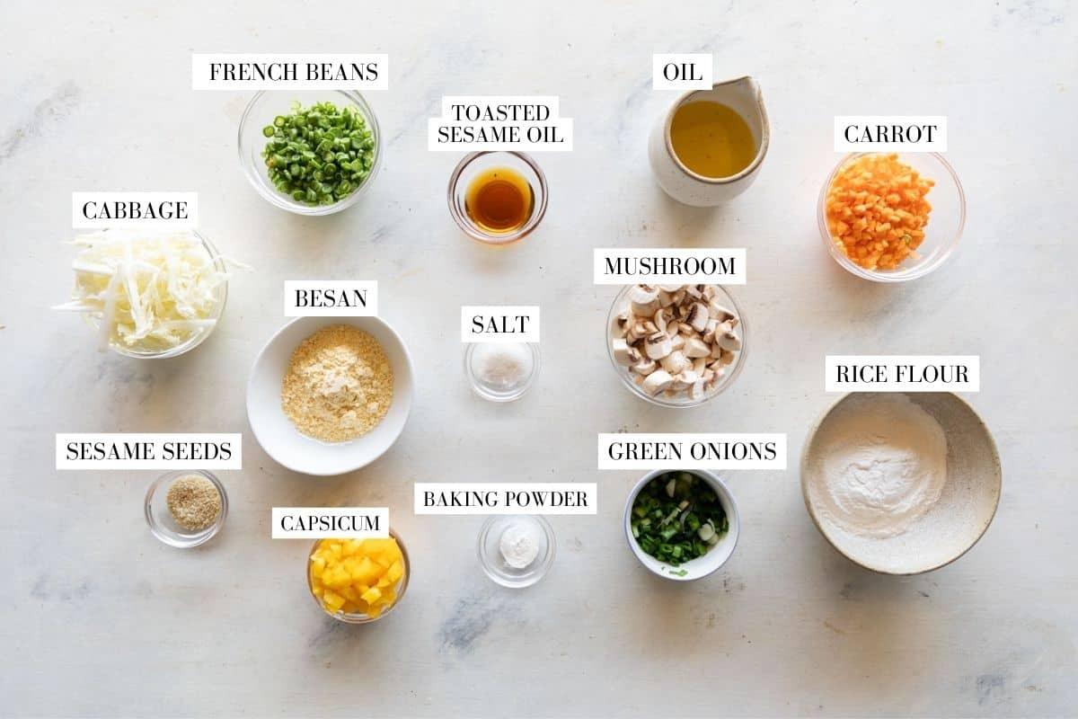 Ingredients for vegetable pancakes laid out with text to identify them