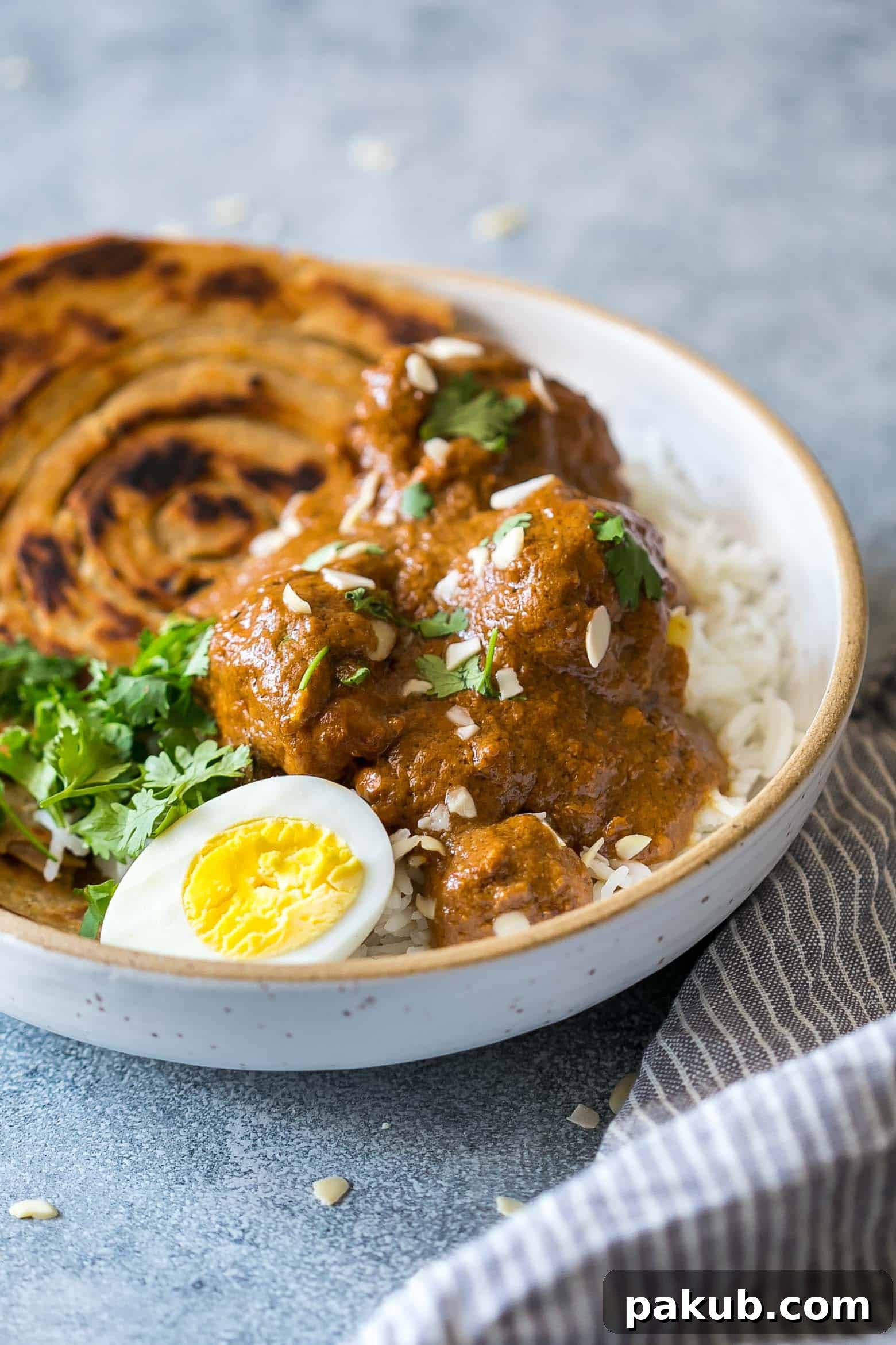 A close-up of Mughlai Chicken, showing its creamy texture and rich, dark gravy, ready to be served.