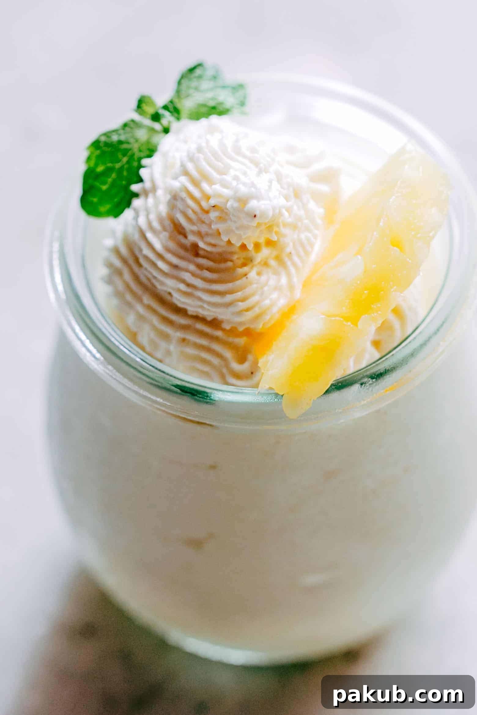 Tropical Escape: Eggless Pineapple Mousse 3 Close-up of fluffy Eggless Pineapple Mousse served in a small glass jar, ready to be enjoyed.
