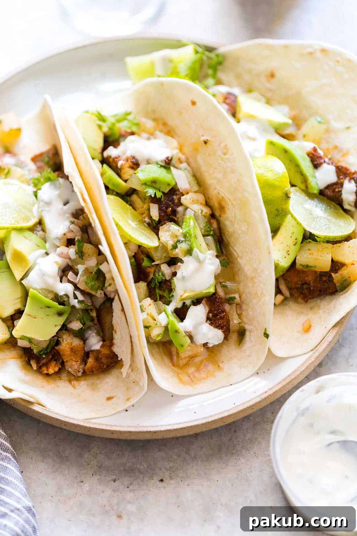 Sunshine Tilapia Tacos with Pineapple Salsa Burst 6 Tilapia Fish Tacos with Pineapple Salsa served on a white plate with a side of Big Banyan's sauvignon blanc.