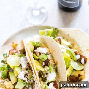 Tilapia Fish Tacos with Pineapple Salsa served on a white plate with a side of Big Banyan's sauvignon blanc.