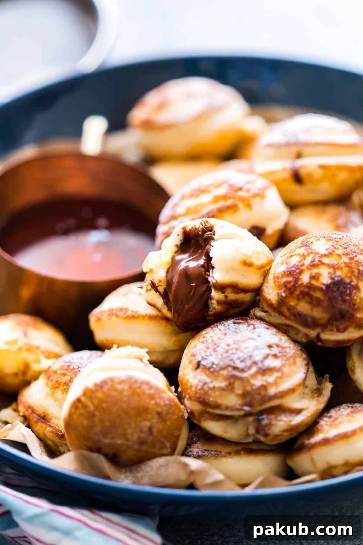 Chocolate Stuffed Mini Pancake Bites served with maple syrup on the side.