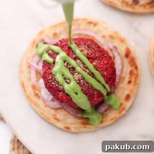 Beetroot tikki served on a flaky paratha with onion rings and garnished with green chutney