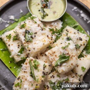 White dhokla served on a banana leaf platter with chutney
