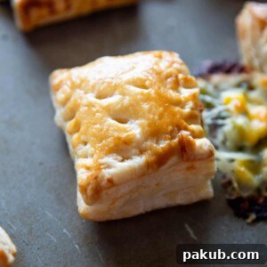 Closeup shot of corn spinach puff with the filling oozing out, highlighting its rich interior