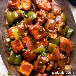 Chilli Paneer served on a platter, showcasing its appealing saucy glaze