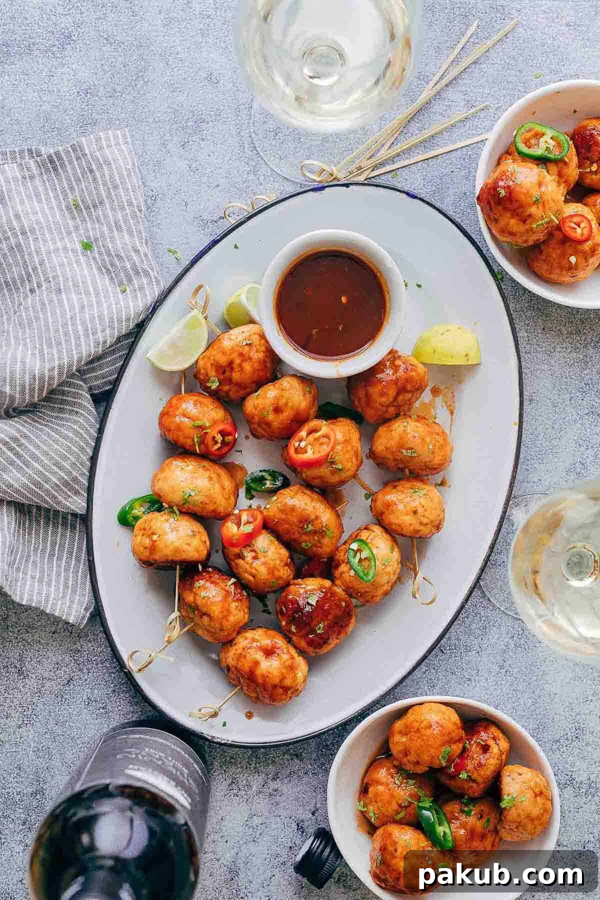Dynamite Glazed Chicken Meatballs 2 Baked Firecracker Chicken Meatballs coated in a vibrant red sauce, garnished with fresh cilantro, ready to be served as an appetizer.
