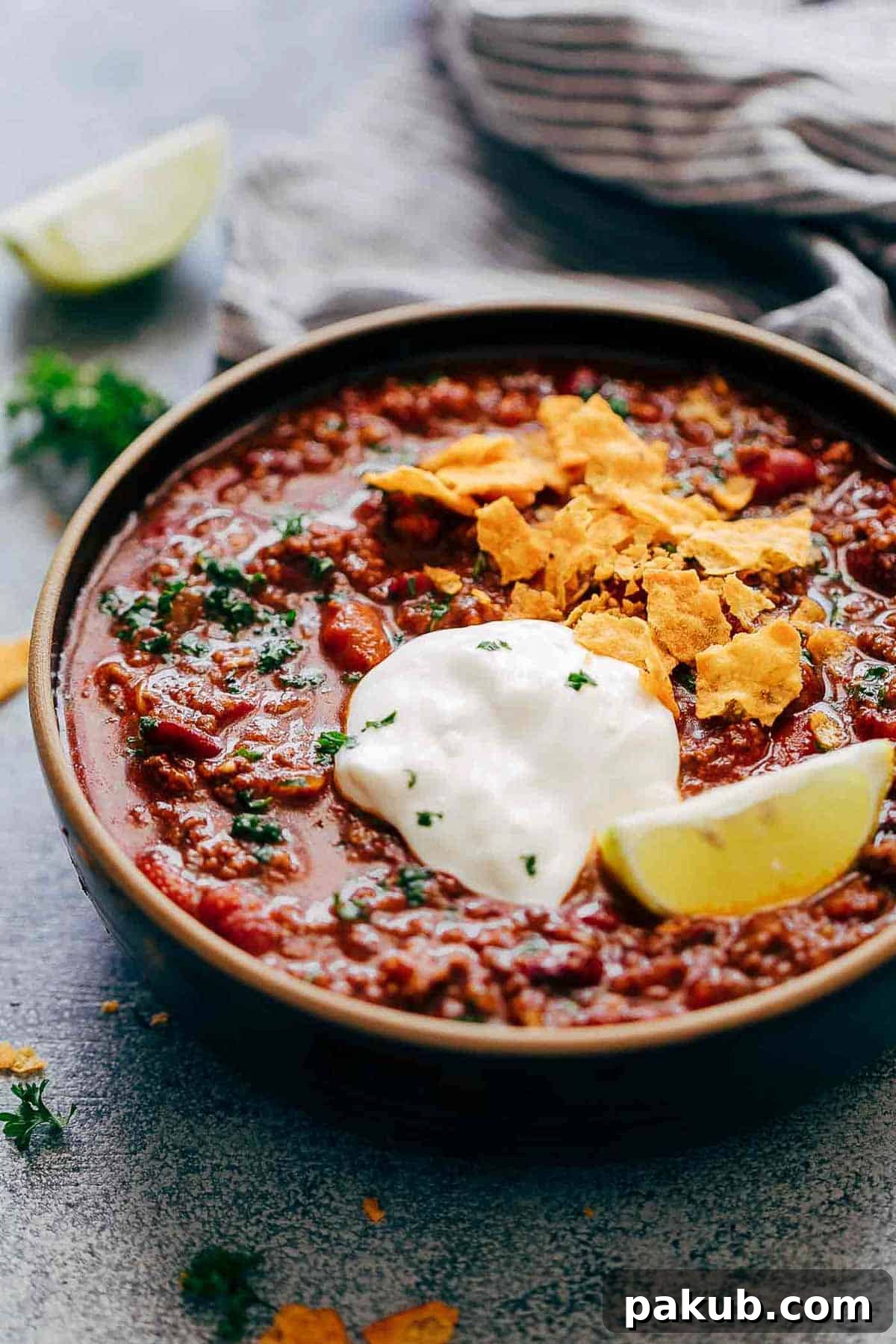 A bowl of Instant Pot Chipotle Chili garnished with a generous dollop of sour cream and fresh cilantro.