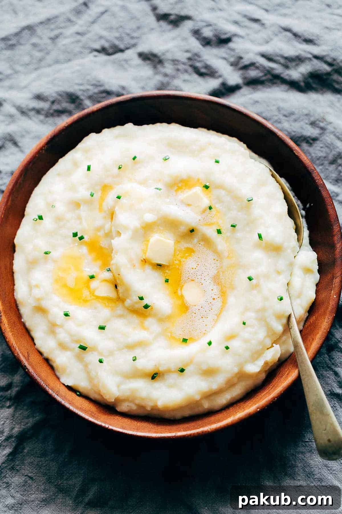 Deliciously creamy garlic mashed potatoes served in an elegant wooden bowl, garnished with fresh herbs.