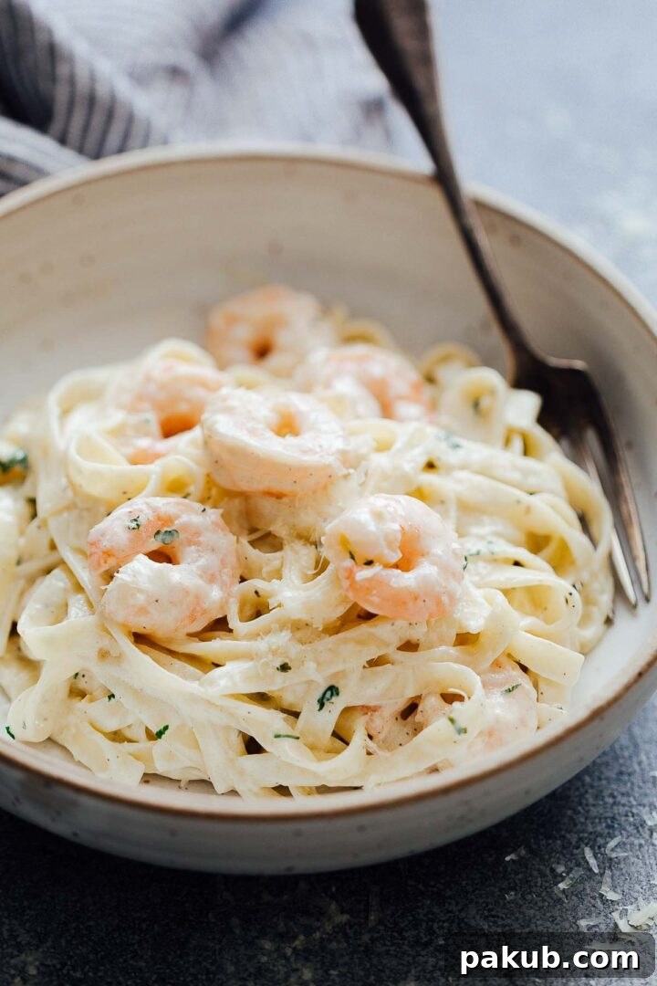 Crafting Creamy Prawn Scampi Pasta A Visual Guide 5 A close-up shot of creamy prawn scampi pasta in a white bowl, ready to be enjoyed.