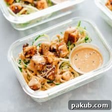 Crispy Sesame Tofu Zucchini Noodles in meal prep containers with peanut sauce.