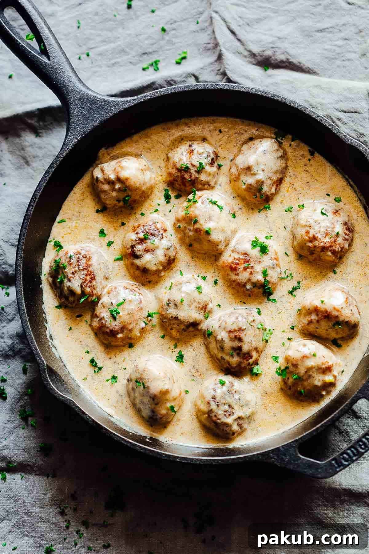 Creamy Chicken Meatballs in Mushroom Sauce in a cast iron pan, ready to serve