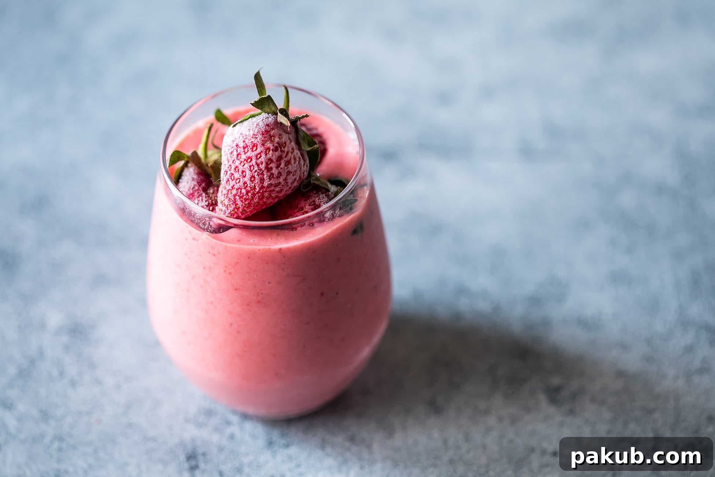 Denver Breakfast Bake 10 A tall glass of a thick, creamy frozen strawberry Greek yogurt smoothie, garnished with fresh strawberries, emphasizing its rich texture and healthy ingredients