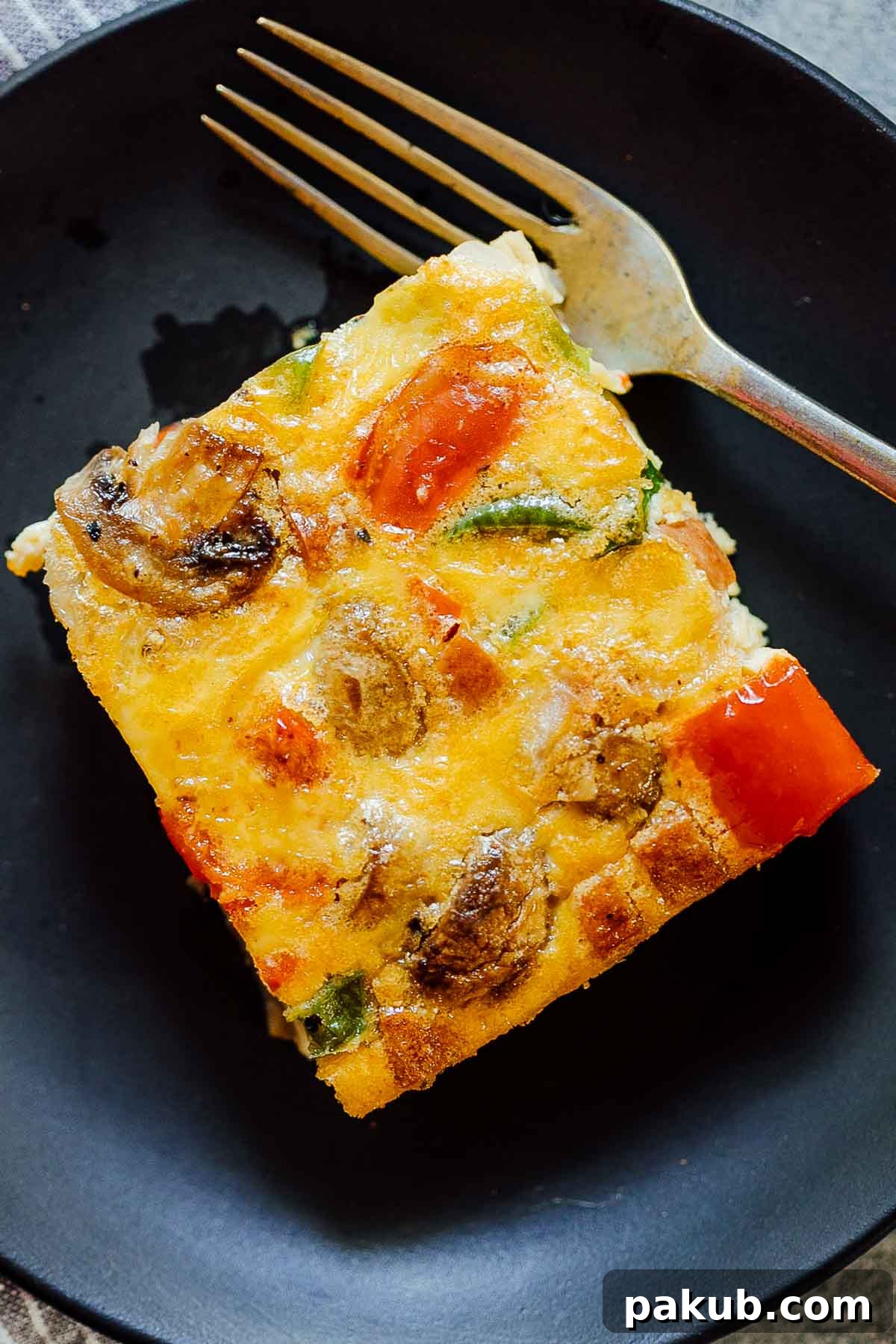 Denver Breakfast Bake 5 A perfectly portioned slice of Baked Denver Omelet Breakfast Casserole served on a white plate, showcasing its fluffy texture and colorful ingredients