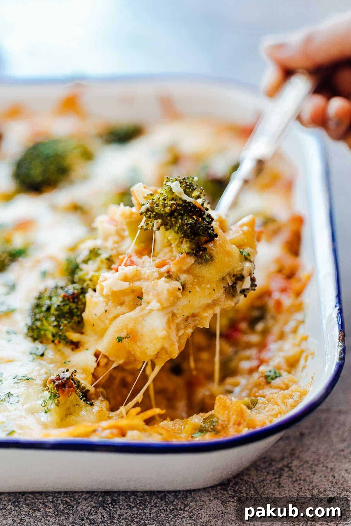 Wholesome Cauliflower Broccoli Bake 3 Cheesy spoonful of healthy cauliflower rice broccoli casserole, showing stretchy cheese