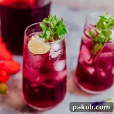 Hibiscus iced tea finished off with mint, lemon and served in glasses.