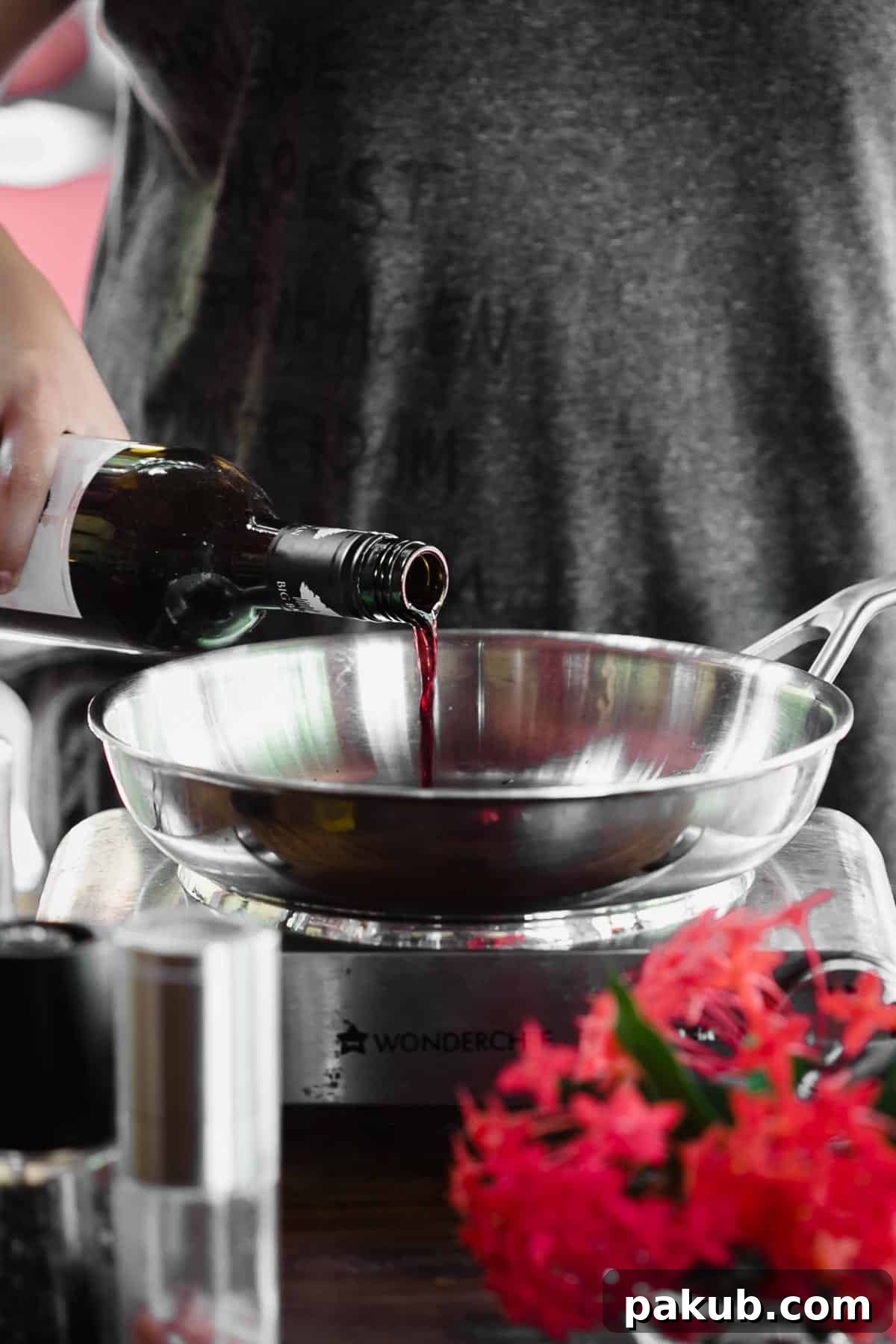 A bottle of red wine and white wine next to a cutting board with fresh ingredients, illustrating the concept of cooking with wine. Grapes and herbs are also visible, suggesting fresh culinary preparation.