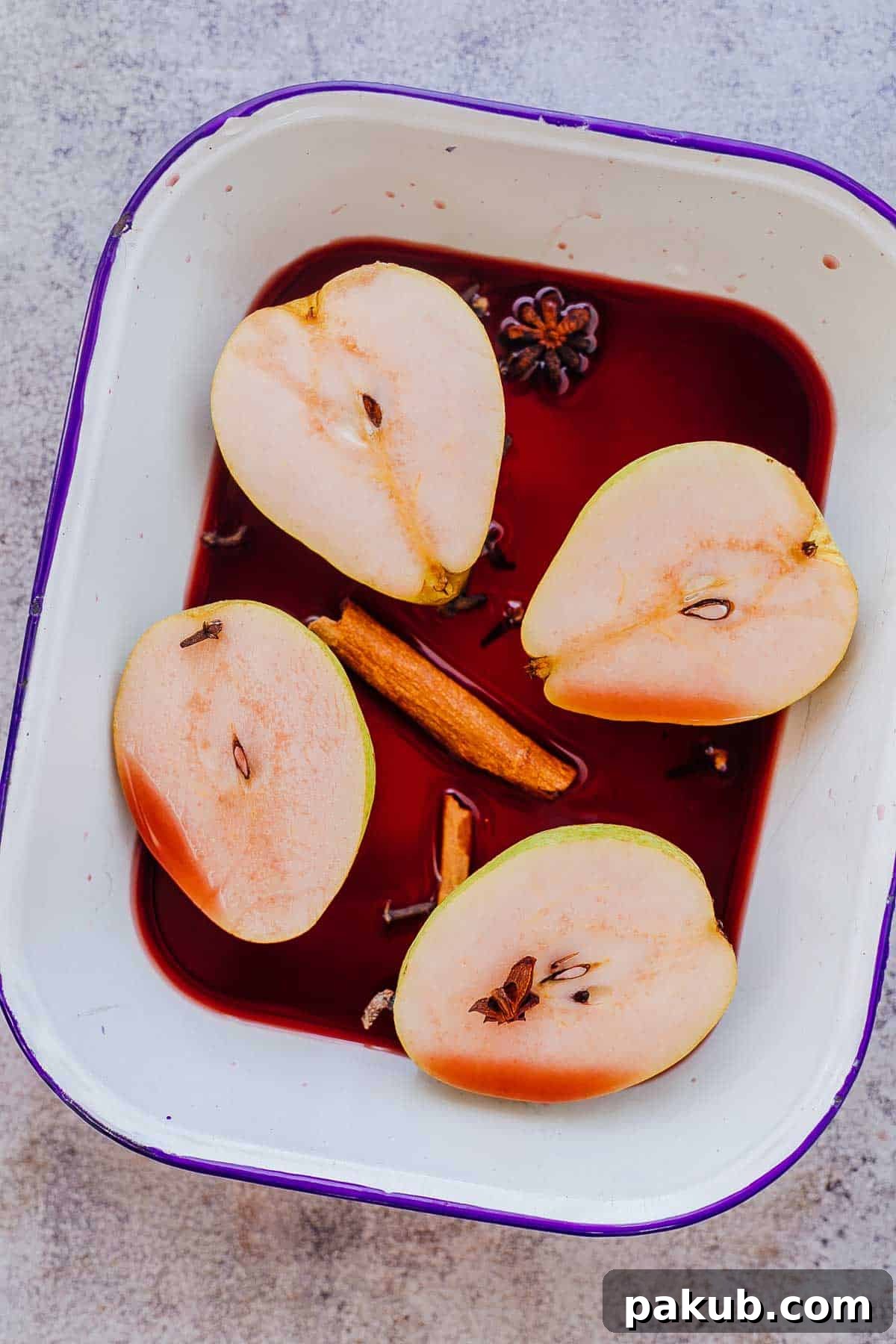 Three perfectly poached pears in a elegant bowl, generously drizzled with a reduced red wine syrup and garnished delicately, showcasing a delightful wine-infused dessert ready to be served.