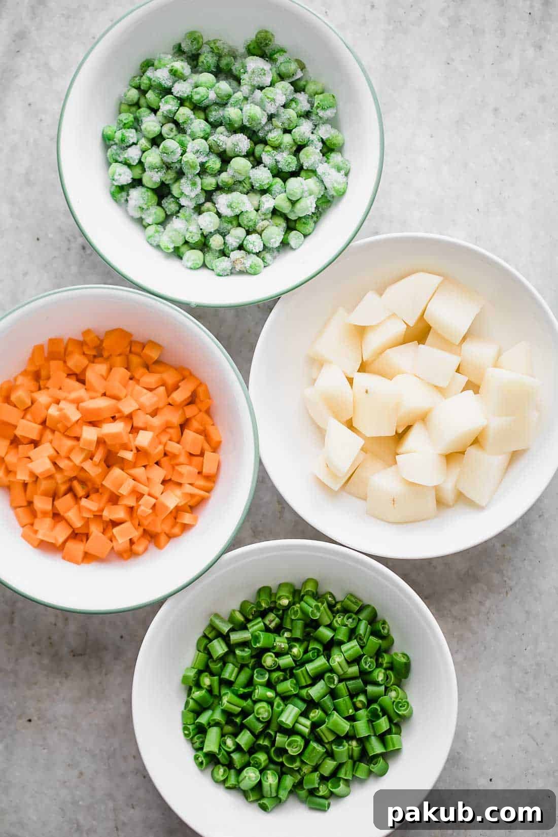 Flavorful One-Pot Pressure Cooker Vegetable Pilaf 3 Mise en place for pressure cooker veg pulao showing bowls of frozen green peas, chopped carrots, sliced beans, and cubed potatoes, ready for cooking