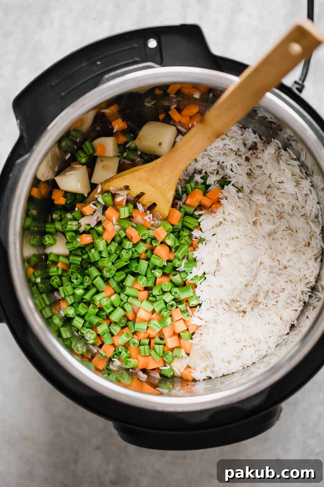 Flavorful One-Pot Pressure Cooker Vegetable Pilaf 4 All the vibrant ingredients, including whole spices, vegetables, and soaked Basmati rice, carefully arranged in an Instant Pot, ready for pressure cooking veg pulao