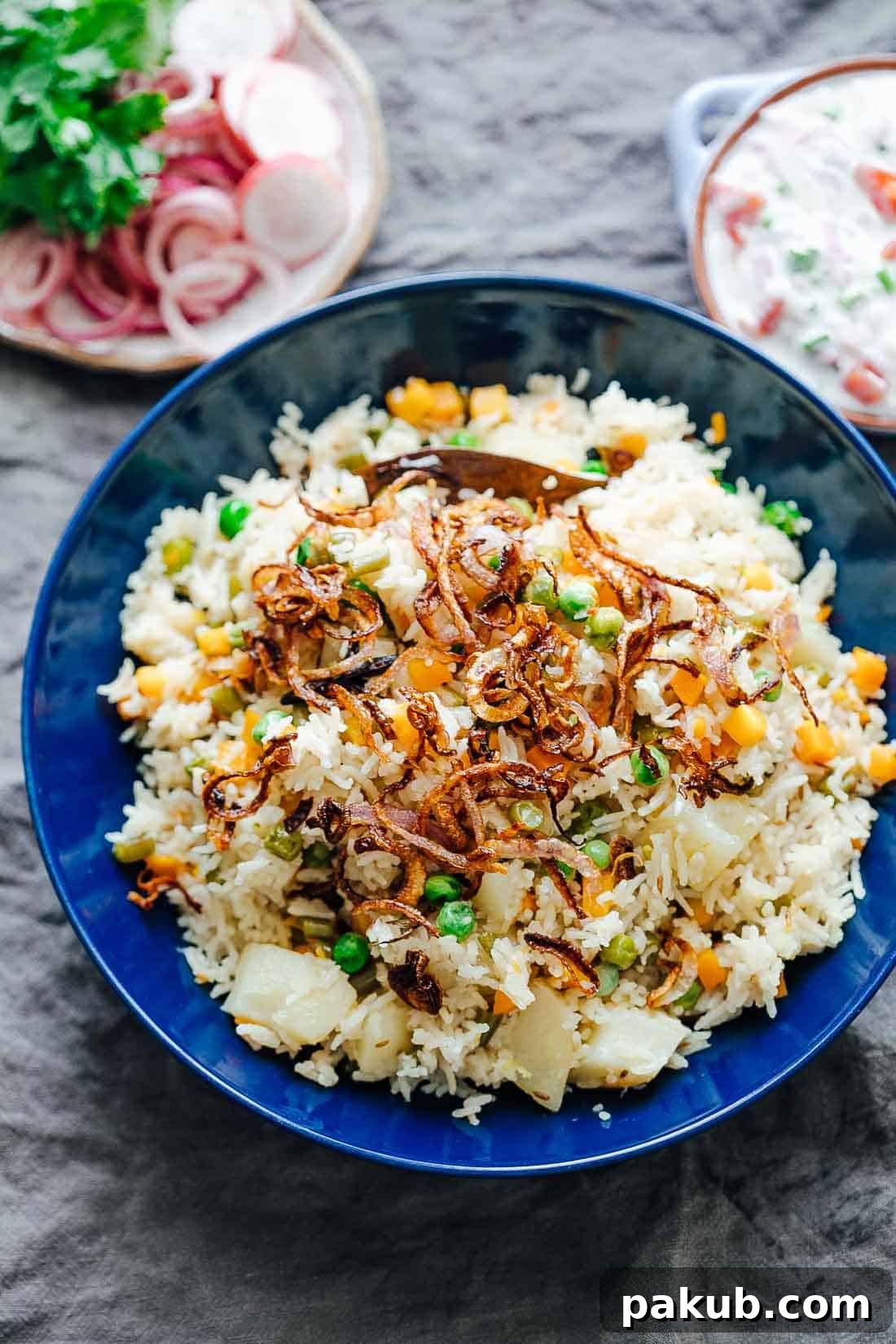 Flavorful One-Pot Pressure Cooker Vegetable Pilaf 5 Close-up shot of fluffy pressure cooker veg pulao served in a white bowl, generously topped with golden crispy fried onions and garnished with fresh herbs, ready to be enjoyed